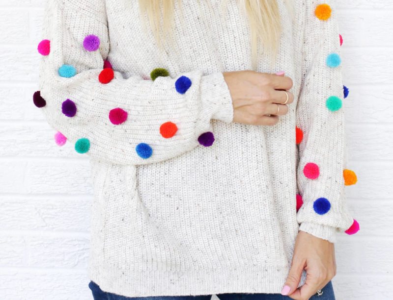 Fille en pull à pompons Fille en pull à pompons