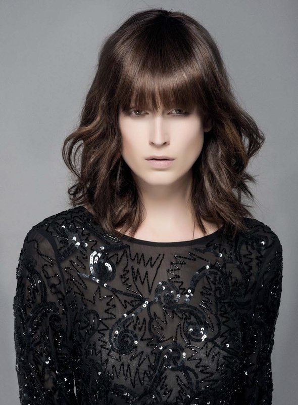 Fille avec une cascade de cheveux moyens et une frange droite Fille avec une cascade de cheveux moyens et une frange droite